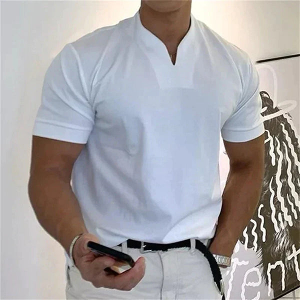 Acclamé dans le t-shirt court haut de gamme d'Olivia's Boutique, une personne l'a associé à un pantalon blanc élégant et tient un smartphone, incarnant un style intemporel. Le fond, une affiche d'art abstrait en noir et blanc, renforce le charme sophistiqué de la scène.